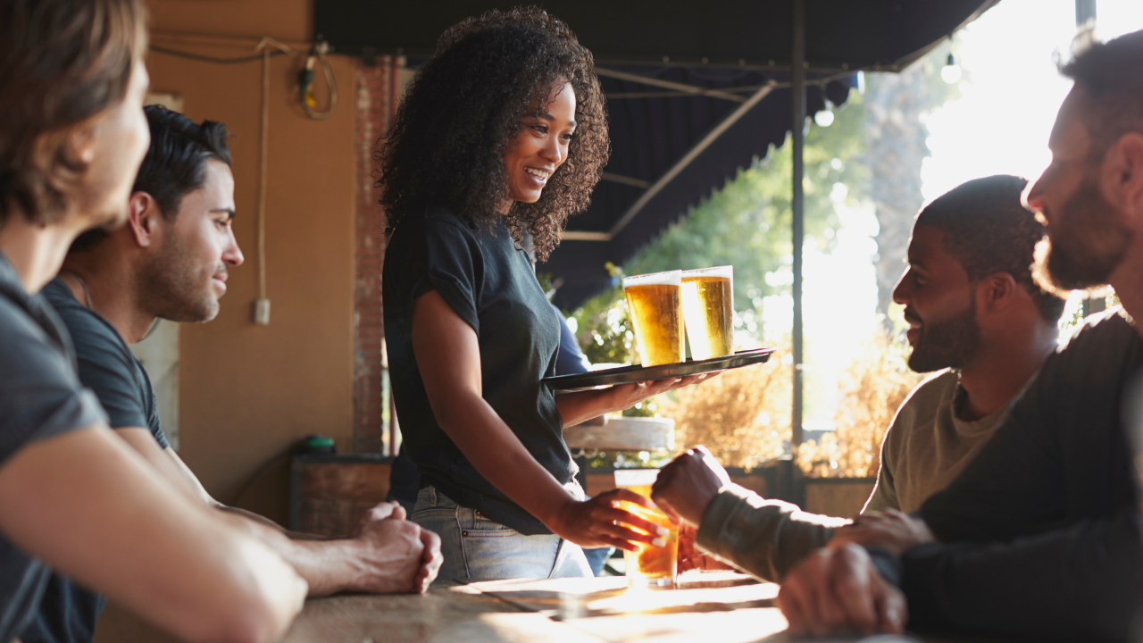waitress serving beer to restaurant patrons