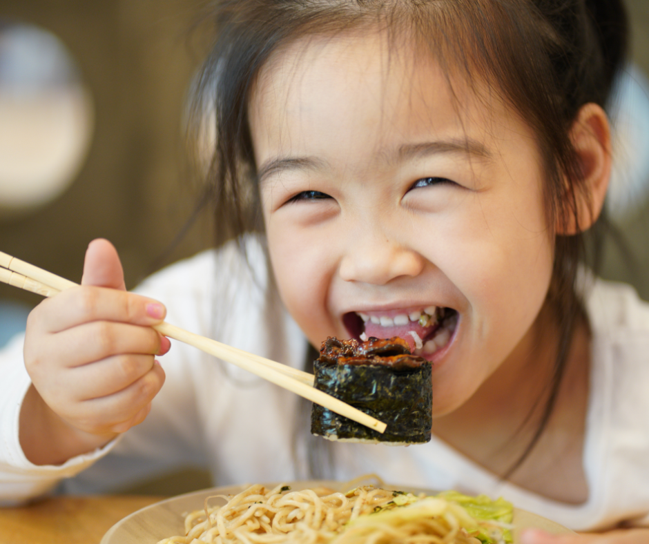 little asian girl eating sushi